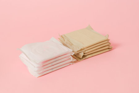 Sanitary napkins packed on a pink background. Menstruation cycle, feminine hygiene and protection....