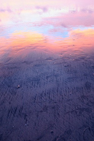 Pink clouds reflection in wet sand of Kuta beach, Bali, Indonesiaの写真素材