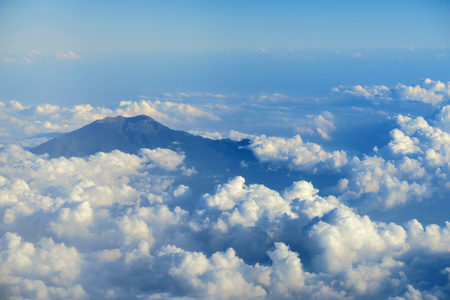 Mountain peak in clouds, aerial view from plane window