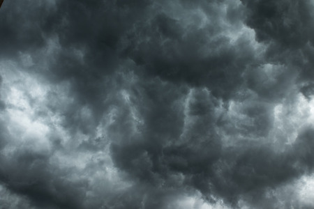 Clusters of black clouds dense obscure the before the rain.の写真素材