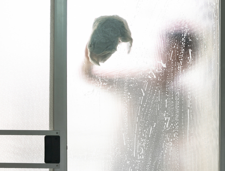 Penumbra of the man behind the glass door. Wiping and cleaned.の写真素材