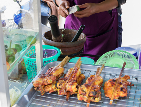 Traders are cooking papaya salad and have grilled chicken on the tray. In Thailand.の写真素材