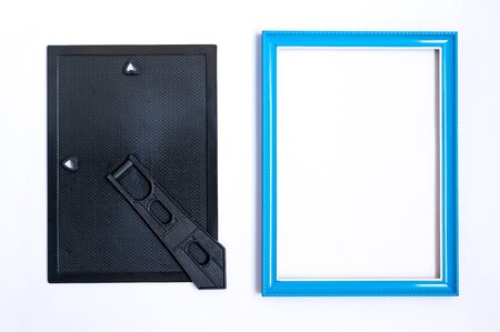 Top view of blue picture frame made wooden with inside empty space. And the back cover black with stand. Placed on white background.の写真素材