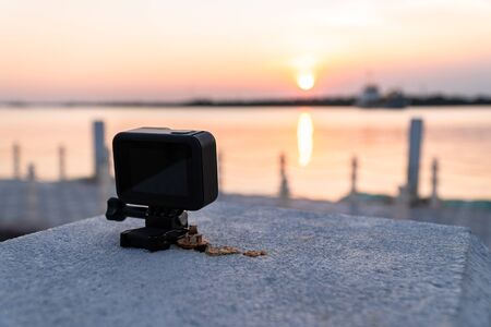 Close up view and low light of small action camera is placed on concrete surface. Which was recording during the sunset on the bank river.の写真素材