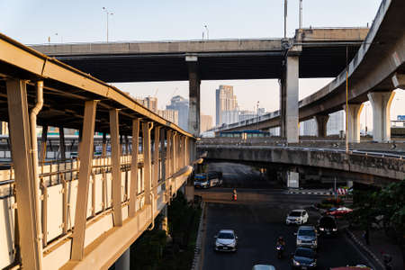 Bang Na Intersection, Bangkok, Thailand-December 22.2019.Low light view in the morning and shade.Skywalk upper on road and below skytrain railway with high cross expressway. Light traffic in morning.のeditorial素材