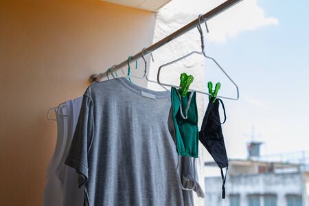 Shade in building. Surgical mask hanging on clothes line after washing to be reused again. Which is during the spread of virus and the shortage of protective equipment.の写真素材