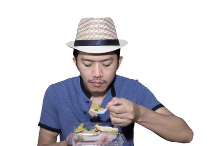 Half body portrait. A man wearing a weave hat. His eating rice packed in plastic box.の写真素材