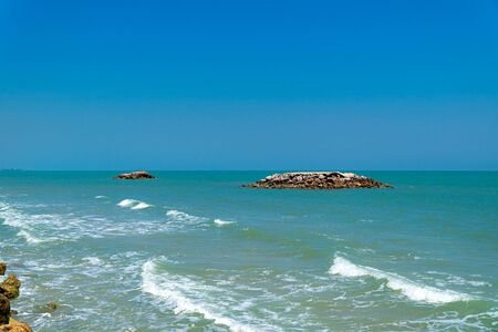 The reef rise above the water surface. Wide view of vast sea with ripples on the coast and colorful...