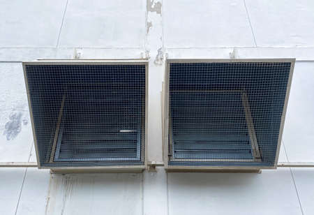 Two large ventilation pipe and attached no the walls of factory building.