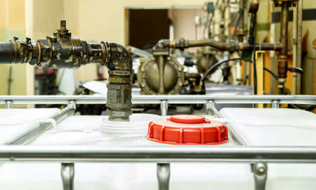 The large white tanks red lid of chemical open. Suction pipes for transferring to main storage tank...