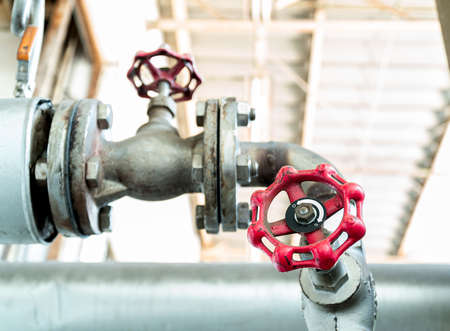 The old rotary valve on pipeline for opening and closing hot water from the boiler.