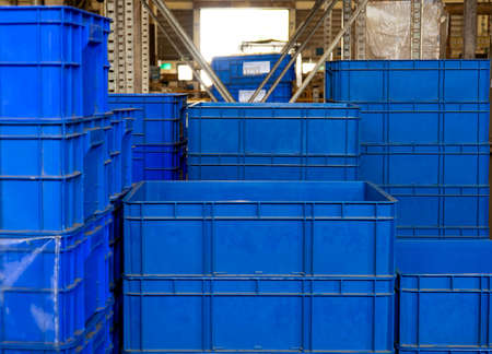 Low light view. Blue boxes stacked for storing product parts from industrial production processes.の写真素材