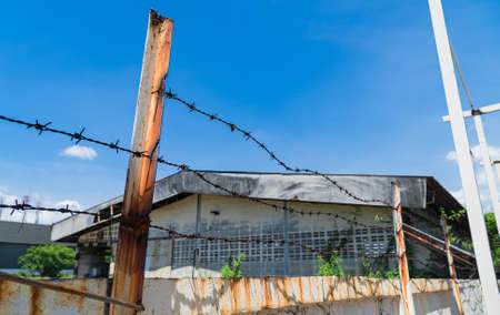 Old wall and barbed wire fence represents the boundaries of personal space.