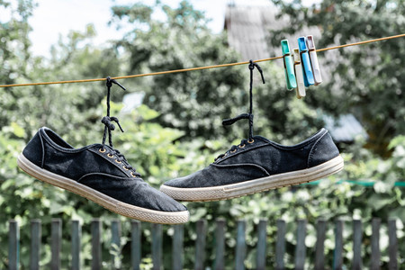 A pair of old sneakers hanging from the shoelacesの写真素材