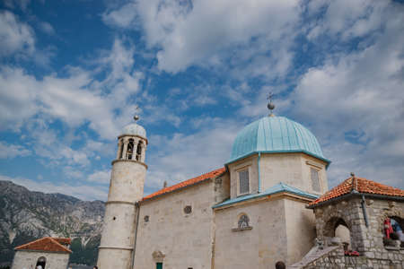 Fjord in Adriatic Sea. Our Lady of the Rock island and Church in Perast on shore of Boka Kotor bay...