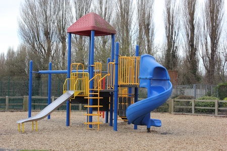 A childrens playground for climbing and sliding on a sand base