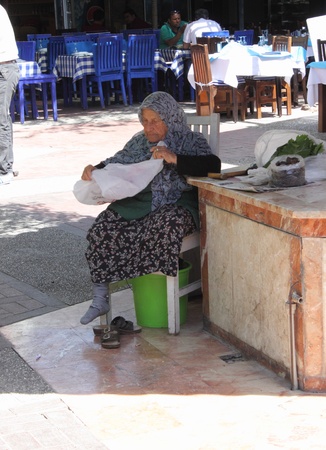 An old turkish lady sitting and having a rest on a chair at a local market in Fethiye, Turkey, 30th may 2013のeditorial素材