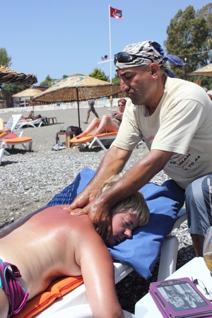 Masseur giving a full body oil massage to a beautiful mature woman on the beach at calis in Turkey on the 30th May 2013のeditorial素材