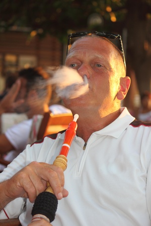 A portrait of a man smoking a hookah waterpipe in a Turkish bazaar