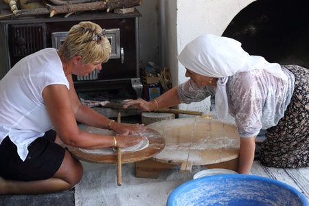  TURKEY,CALIS, 1st AUGUST 2013 - Old Turkish ladies making traditional turkish bread and pancakes and teaching an english lady how to do it herselfのeditorial素材
