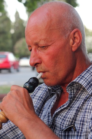 A portrait of a man smoking a hookah waterpipe in a Turkish bazaarの写真素材