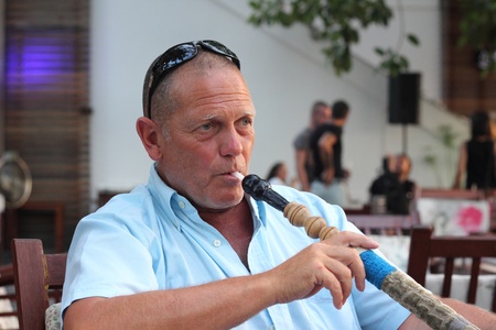 A portrait of a man smoking a hookah waterpipe in a Turkish bazaar