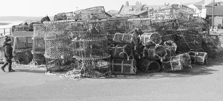 AVON, HAMPSHIRE, ENGLAND 9TH MARCH 2014  Lobster and crab pots on the quayside with a young child at Avon in Hampshire on the 9th march 2014のeditorial素材