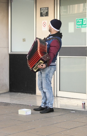 A busker playing his accordion on the streets of portsmouth, england 2014のeditorial素材