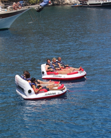 Turkey, July 2014 - Tourists having fun riding on inflatables being pulled by a speedboatのeditorial素材