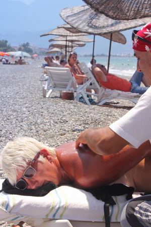 Masseur giving a full massage to a beautiful mature woman on the beach at calis in Turkey on the 19th july 2014のeditorial素材