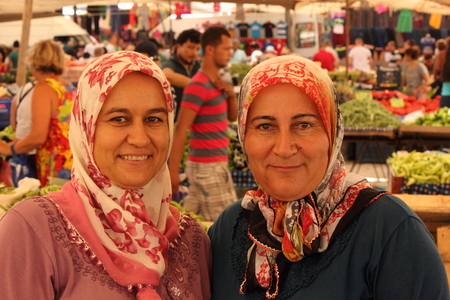 CALIS, TURKEY - 20TH JULY, 2014  Two turkish ladies with a beautiful smile selling fresh fruits and vegetables at a local produce market in Calis, Turkey 20th july 2014のeditorial素材