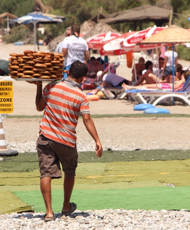 A turkish pastry seller selling his goods along calis beach in turkey 2014