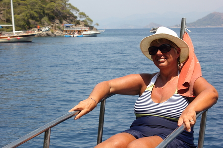 An english lady relaxing while on a boat trip around the bays at fethiye in turkey, 2015の写真素材