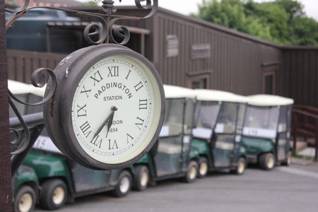 10TH JUNE 2016, OKEHAMPTON, ENGLAND: A clock on the first tee with golf buggies in the background on a golf course at okehampton,england, 10th june 2016のeditorial素材