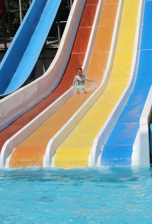 A young boy having fun on a water slide in a waterpark while on vacation in turkey