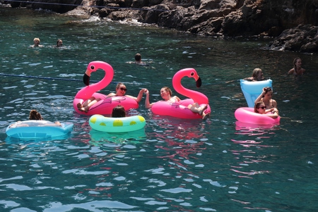22ND JULY 2016,FETHIYE, TURKEY: A group of tourists swimming and using rubber rings as floatation aids in the sea while on vacation in Fethiye, Turkey , 22nd july 2016のeditorial素材