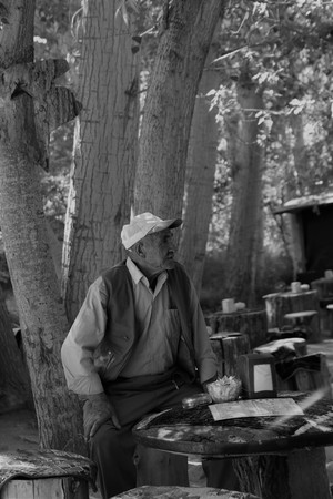 24TH JULY 2017, CAPPADOCIA,GOREME,TURKEY: An old turkish male sitting on a log seat at cappadocia in turkey, 24th july 2017のeditorial素材