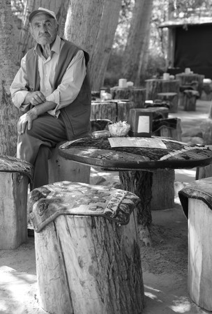 24TH JULY 2017, CAPPADOCIA,GOREME,TURKEY: An old turkish male sitting on a log seat at cappadocia in turkey, 24th july 2017のeditorial素材