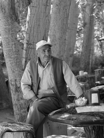 24TH JULY 2017, CAPPADOCIA,GOREME,TURKEY: An old turkish male sitting on a log seat at cappadocia in turkey, 24th july 2017のeditorial素材
