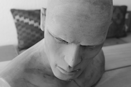 A clay model of a males head and shoulders in black and whiteの写真素材
