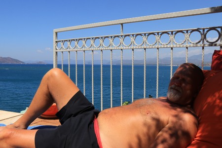 An Englishman sunbathing with the sea and mountains in the background, 2017のeditorial素材