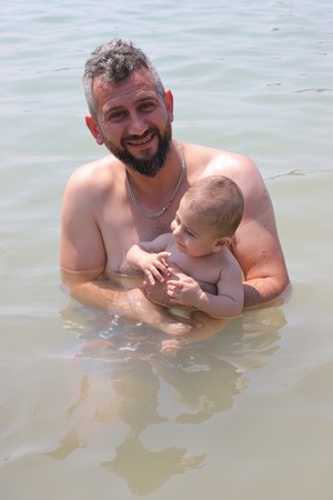6TH AUGUST 2017,OULDENIZ,TURKEY : An unknown turkish male in the sea with his baby in ouldeniz, turkey,6th august 2017のeditorial素材