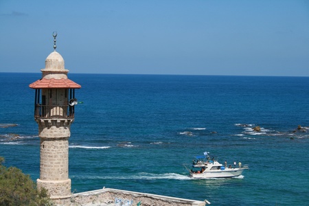 mosque tower in old Jaffa overseeing the Mediterranean sea and boatの写真素材
