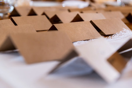 tableware and table decorations at celebrations place cards made of brown cardboard in a bohemian and rustic style on a white tableclothの写真素材
