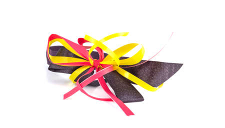 Red yellow black ribbon loop bow on a white backgroundの写真素材