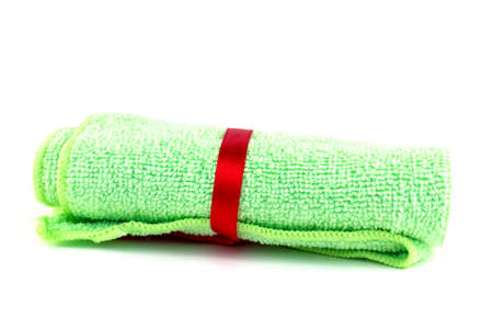 Green roll towels with red ribbon on white backgroundの写真素材