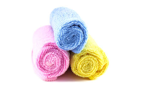 Red yellow and blue towel rolled up on a white backgroundの写真素材