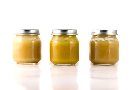 Three jars of fruit puree in a rowの写真素材