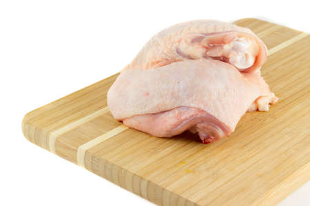 Two chicken thighs on a wooden boardの写真素材