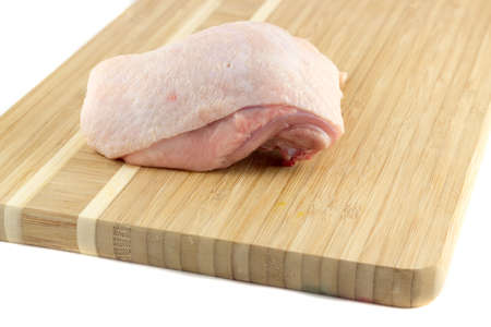 Chicken thighs on a wooden boardの写真素材